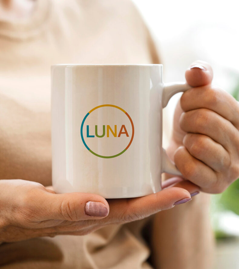 Person holding a mug with a LUNA logo