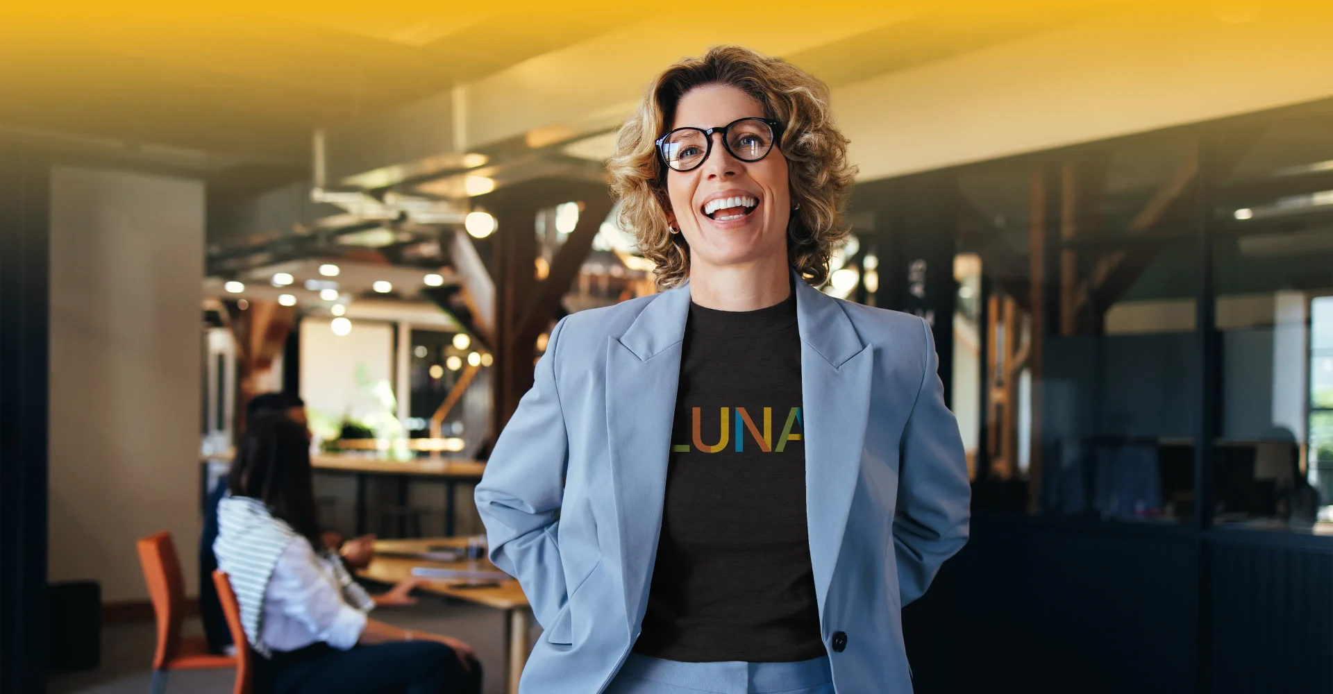 Latina woman in a blue blazer with a shirt underneath that says 