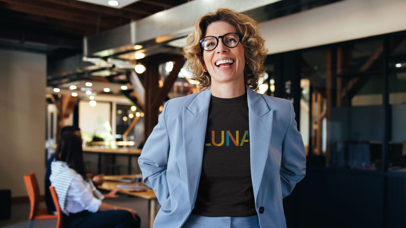 Latina woman in a blue blazer with a shirt underneath that says 