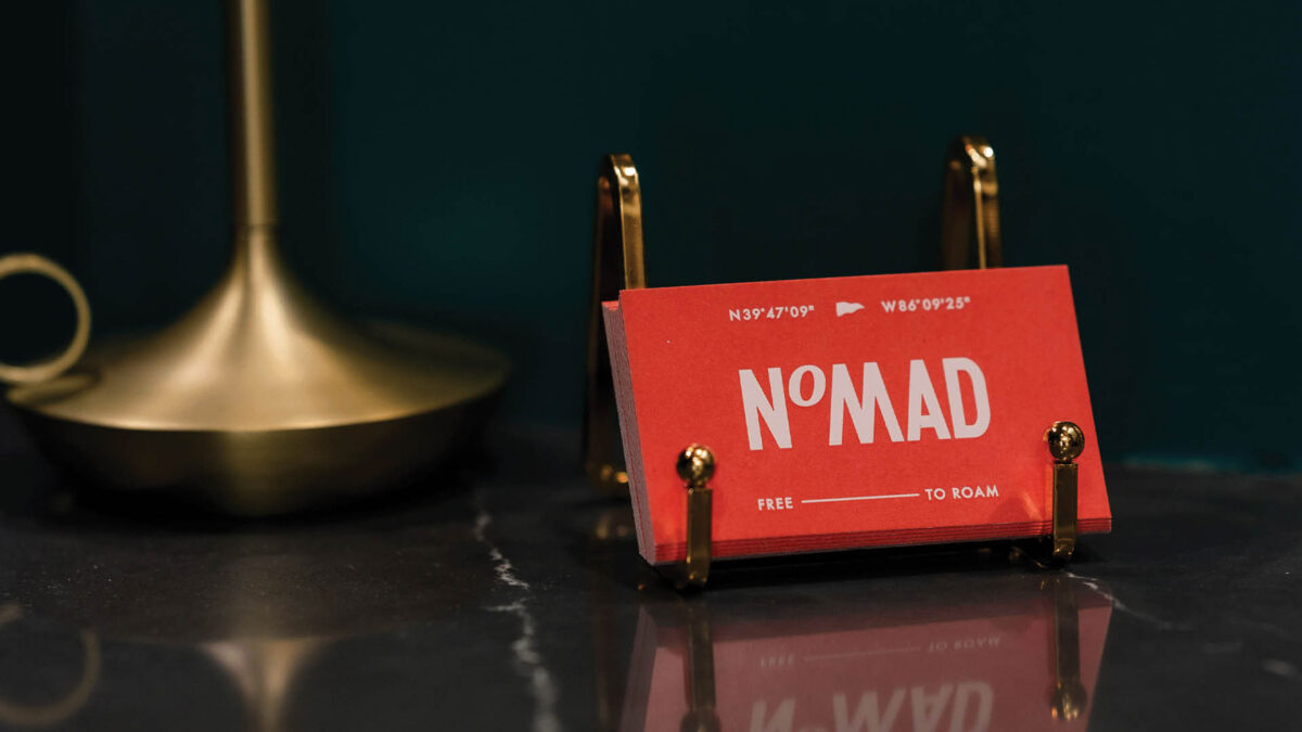 nomad business cards in an antique brass holder
