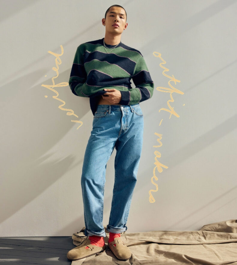 an abercrombie model in jeans and a sweater with handwriting in the image