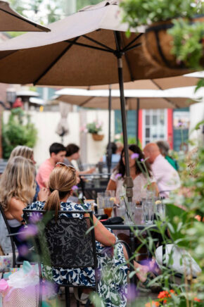 a group of women sitting at an outdoor restaurant table